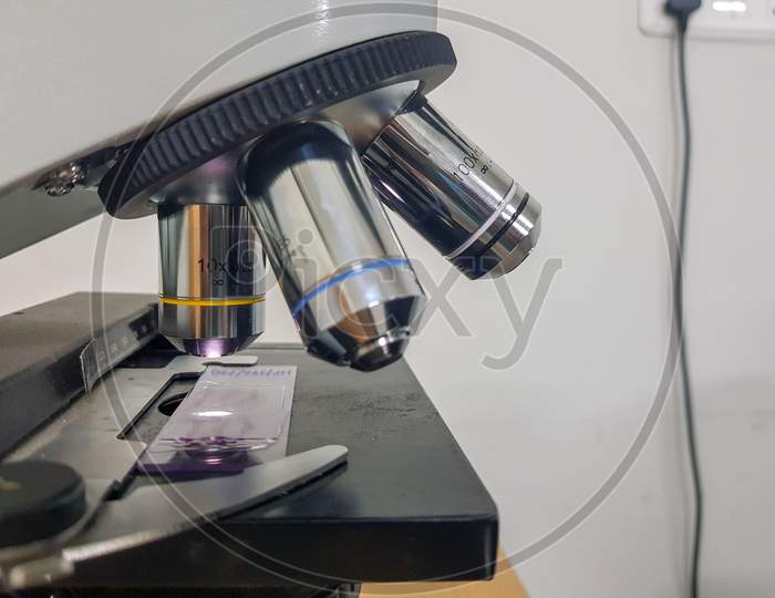Close Up View Of A Light Microscope With Glass Slide Focussed