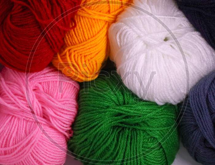 A Ball Of Pink Green Red Yellow And White Colored Wool