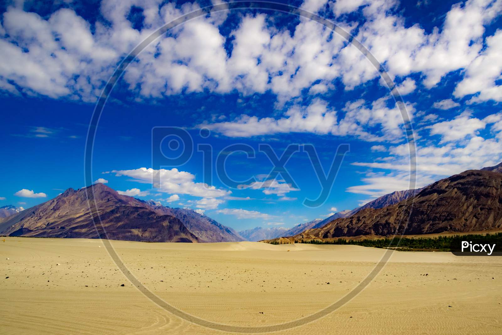 High Dynamic Range Image Of Barren Mountain In A Desert With Deep Blue Sky And White Patchy Clouds In Ladakh, Jammu And Kashmir, India