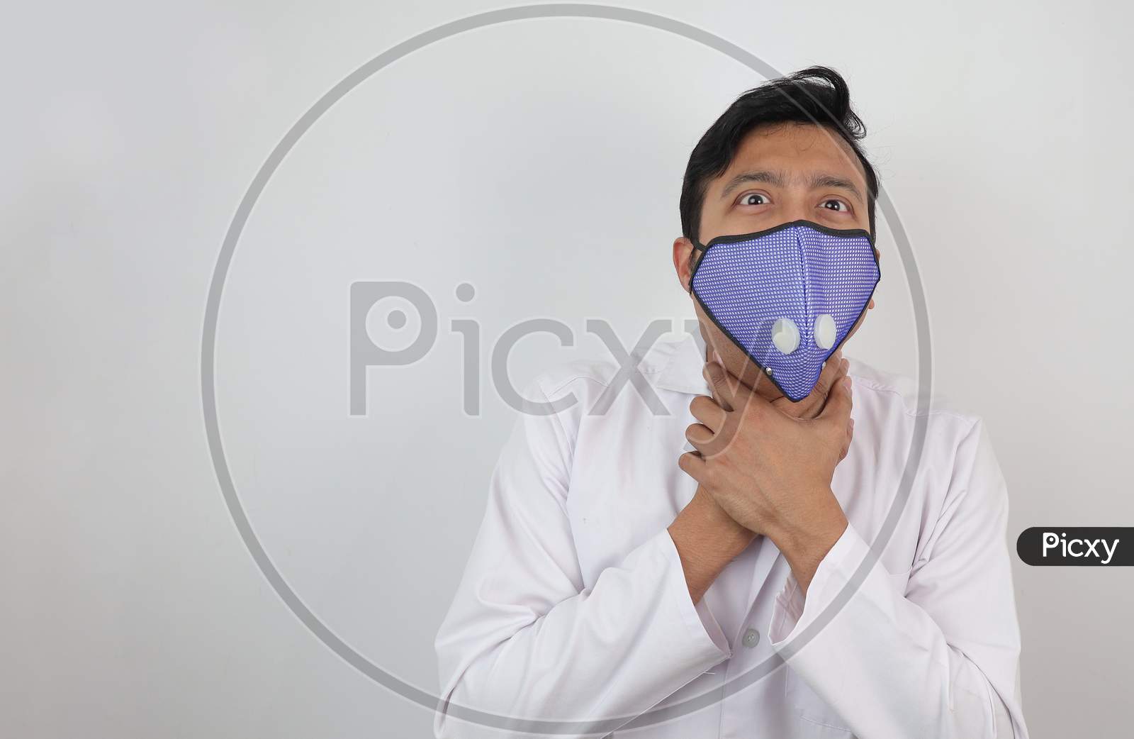 A Male Doctor In Mask And White Coat Holding His Neck With Both Hands With Choking Expression Isolated In White Grey Background With Space For Text