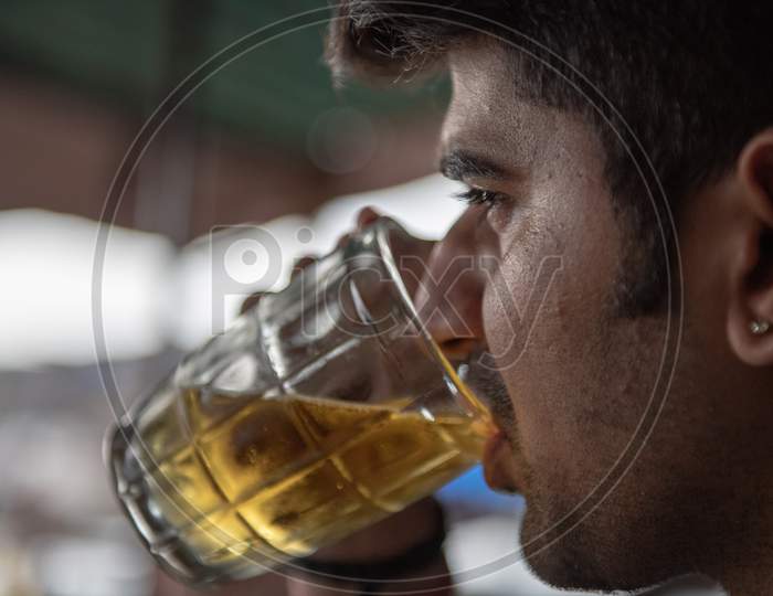 A Man Drinking Beer in a Pint Glass Closeup