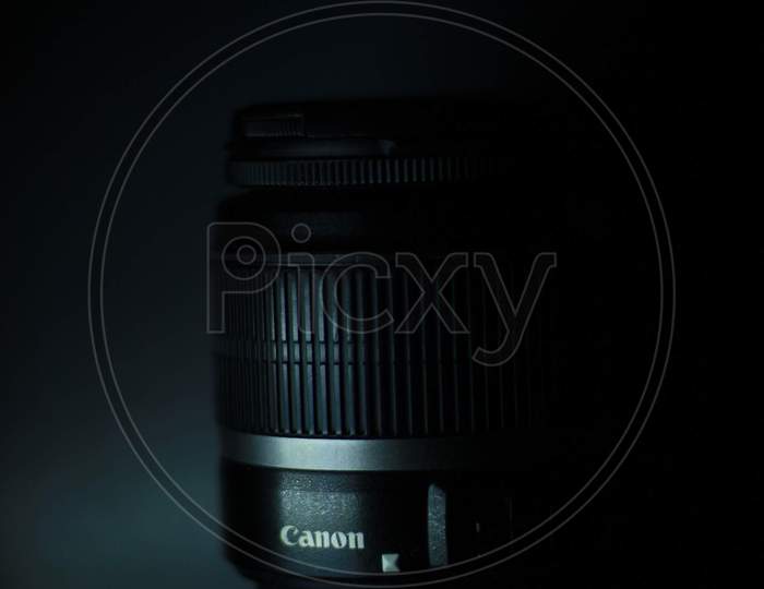 Canon 18-55mm Lens Over an Grey Background With Light Play