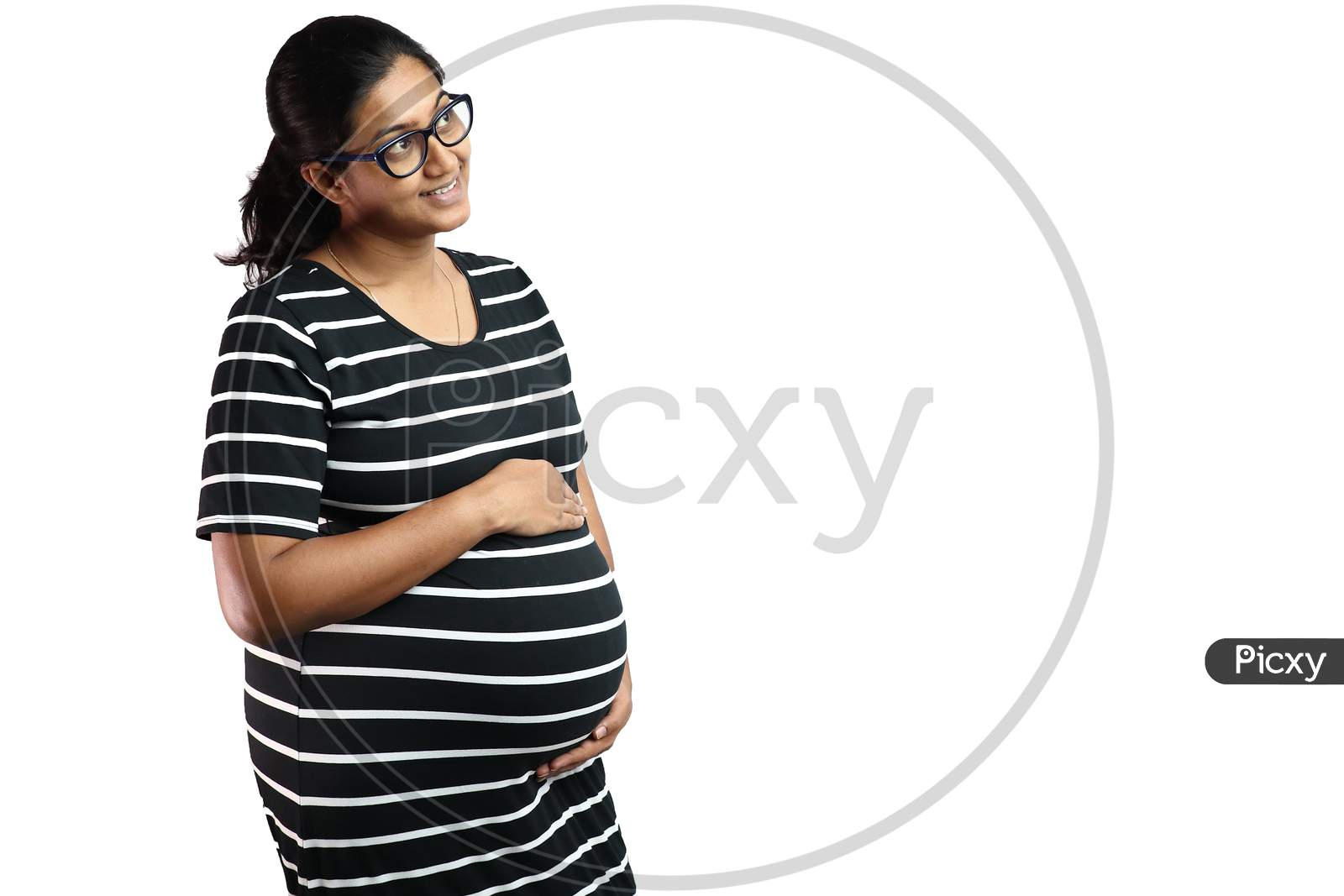 A Pregnant Lady Wearing Spectacles With Black Dress With White Stripes And Hands On Belly Looking Up In Delight With Copy Space For Text.