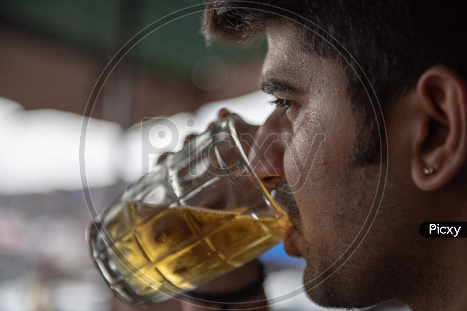 A Man Drinking Beer in a Pint Glass Closeup