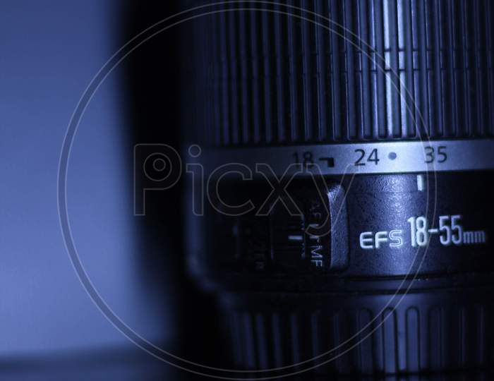 Canon 18-55mm Lens Over an Grey Background With Light Play