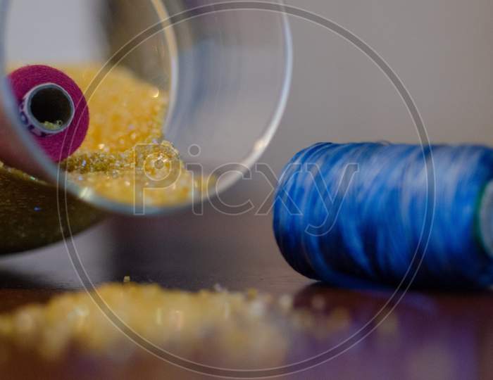 Embroidery Beads And Colourful Sewing Threads On Wooden Table Background