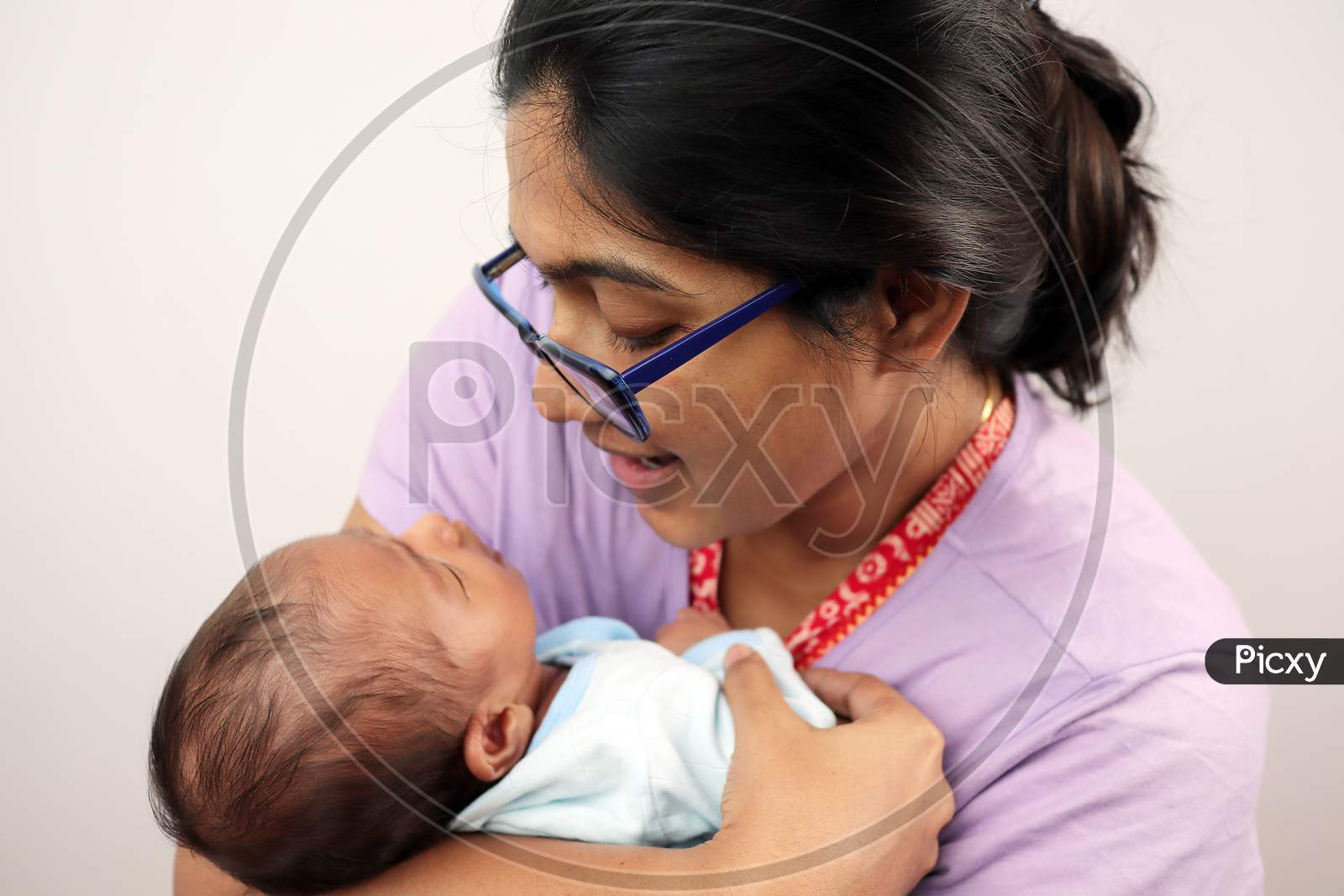A Mother Cuddling Her Baby Isolated In White Background With Space For Text.