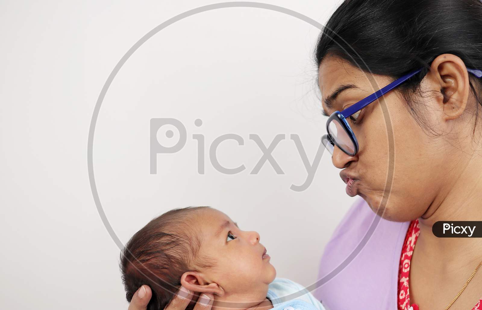 A Mother Making Funny Face At Her Baby Isolated In White Background With Space For Text.