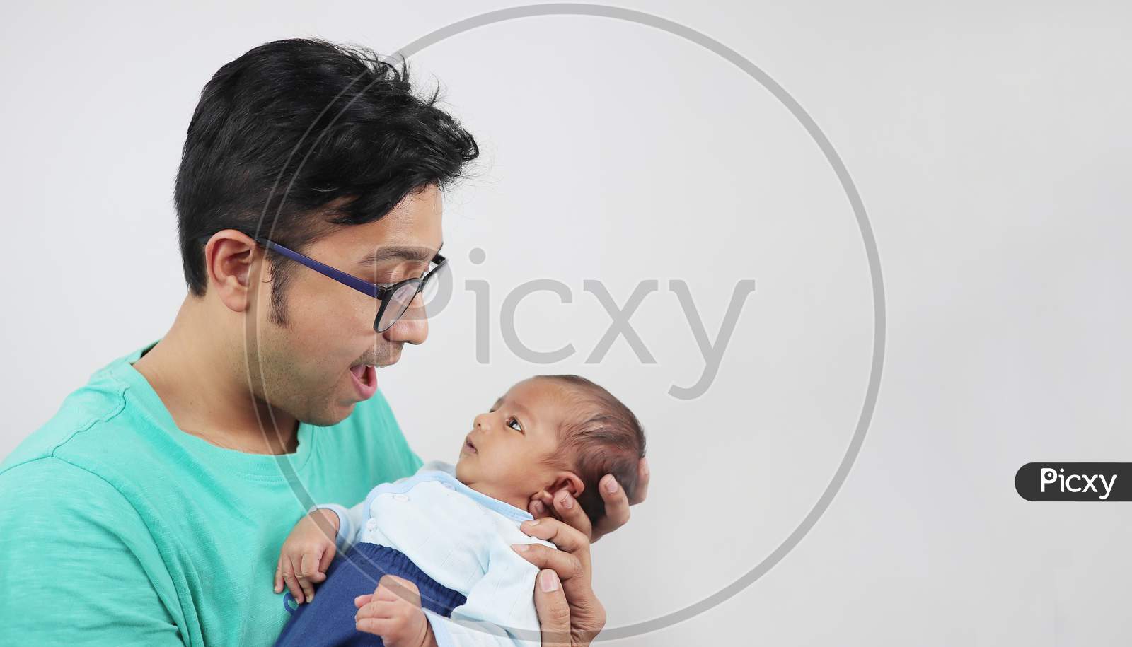 A Father Making Funny Face At His Baby Isolated In White Background With Space For Text.