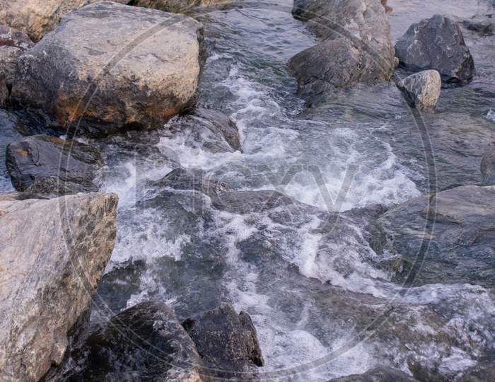 Clear White Water Flowing Between Huge Rocks