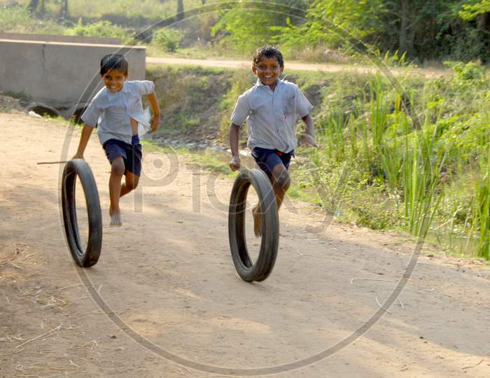 Rural Indian School Children Playing With  Tyres in Rural Villages