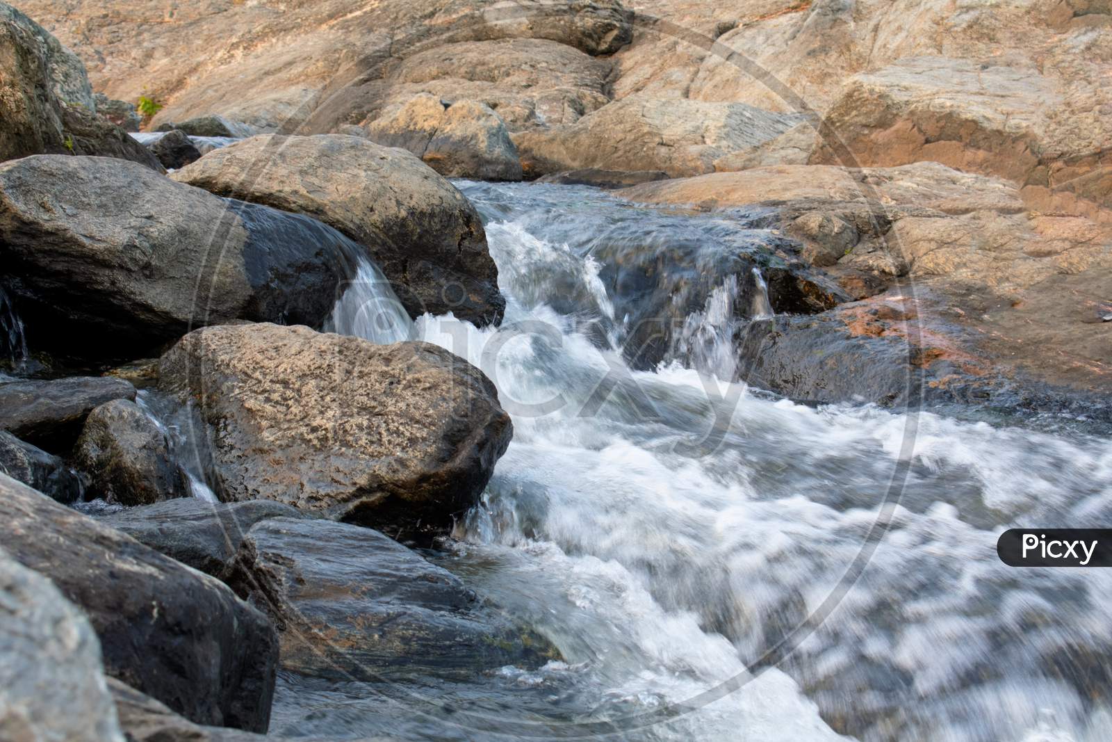 Long Exposure Shot Of A Water Flowing Between The Rocks 2020