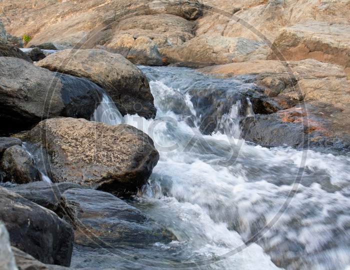 Long Exposure Shot Of A Water Flowing Between The Rocks 2020