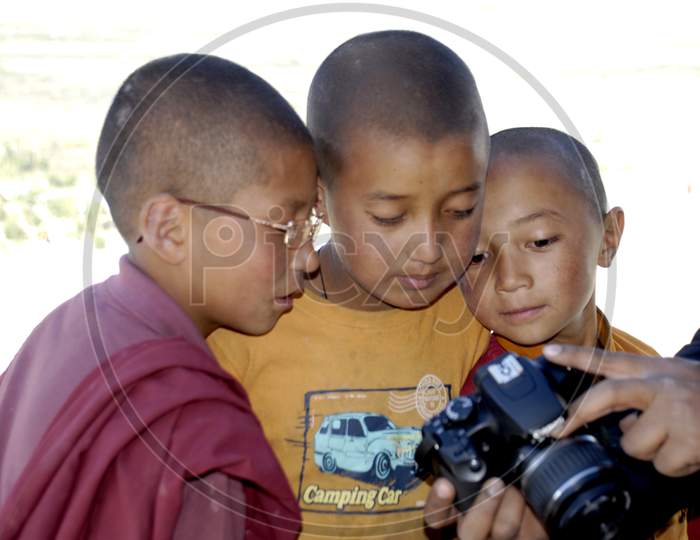 Buddhist Monk Children Looking At a DSLR Camera