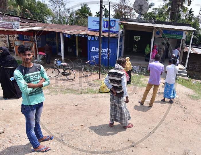 People Standing At Safe Distances In A Queue Wait To Collect Money Outside Atm During The Nationwide Lockdown Imposed In Wake Of Coronavirus Pandemic At Samaguri In Nagaon District Of Assam On April 10,2020.