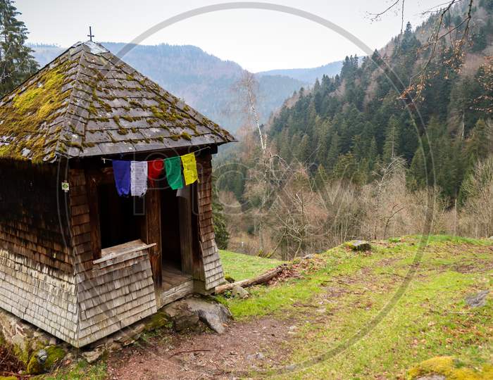 Small Open Building With Colorful Flags In The Black Forest.