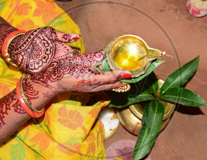 Indian woman performing worship along with lighting oil lamp
