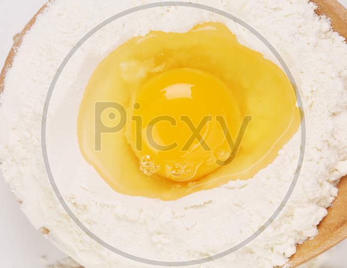 Egg Yolk On Flour And Wooden Platter. Whole Background.