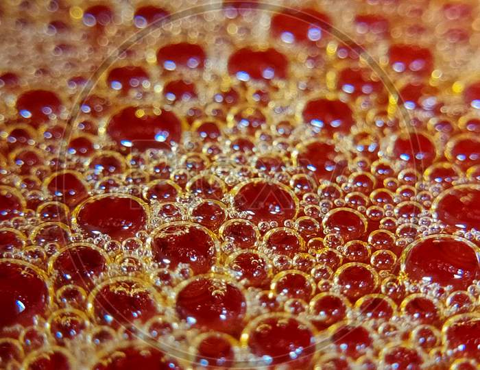 Photo of red colour bubbles on water surface. Design of water bubbles on water surface.