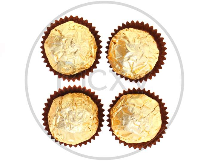 Four Chocolate Gold Bonbons. Isolated On A White Background.