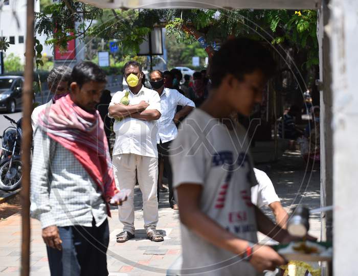 Migrant workers wait for their turn at a free food serving GHMC Annapurna Counter in Madhapur amid nationwide lockdown due to coronavirus pandemic, April 10,2020, Covid 19