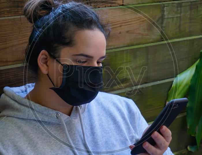 Young woman with medical mask and smartphone