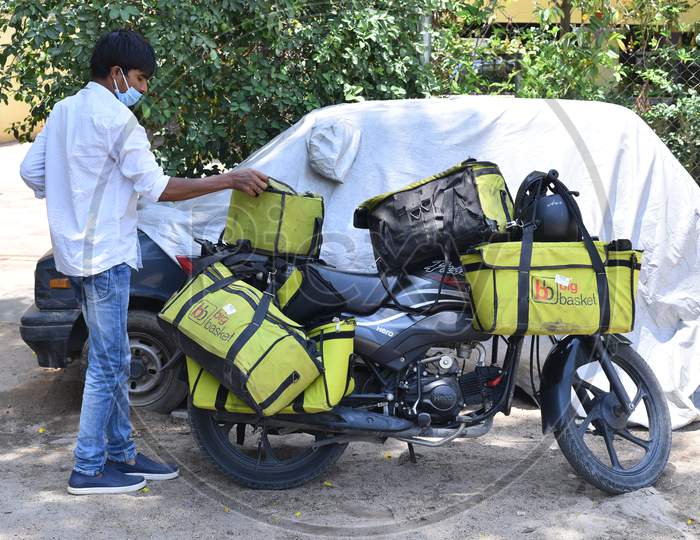 An online grocery service delivery person takes his bag to deliver at a residence in Madhapur, Big Basket.