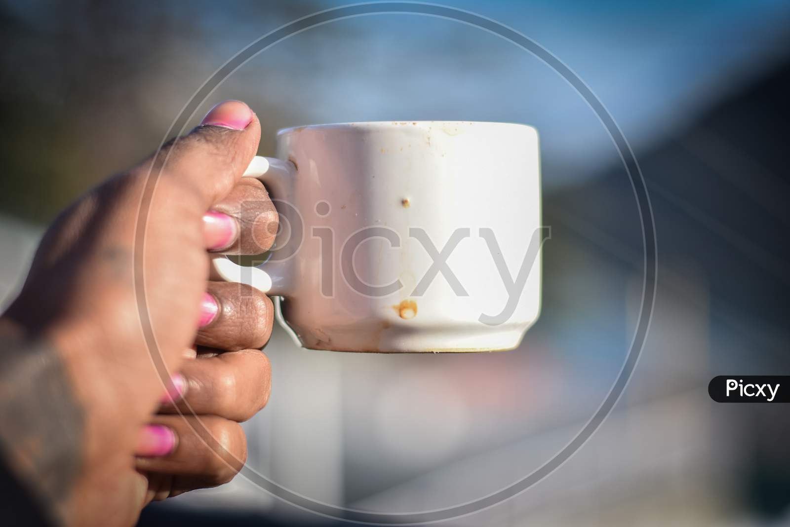 man holding a white cup of coffee