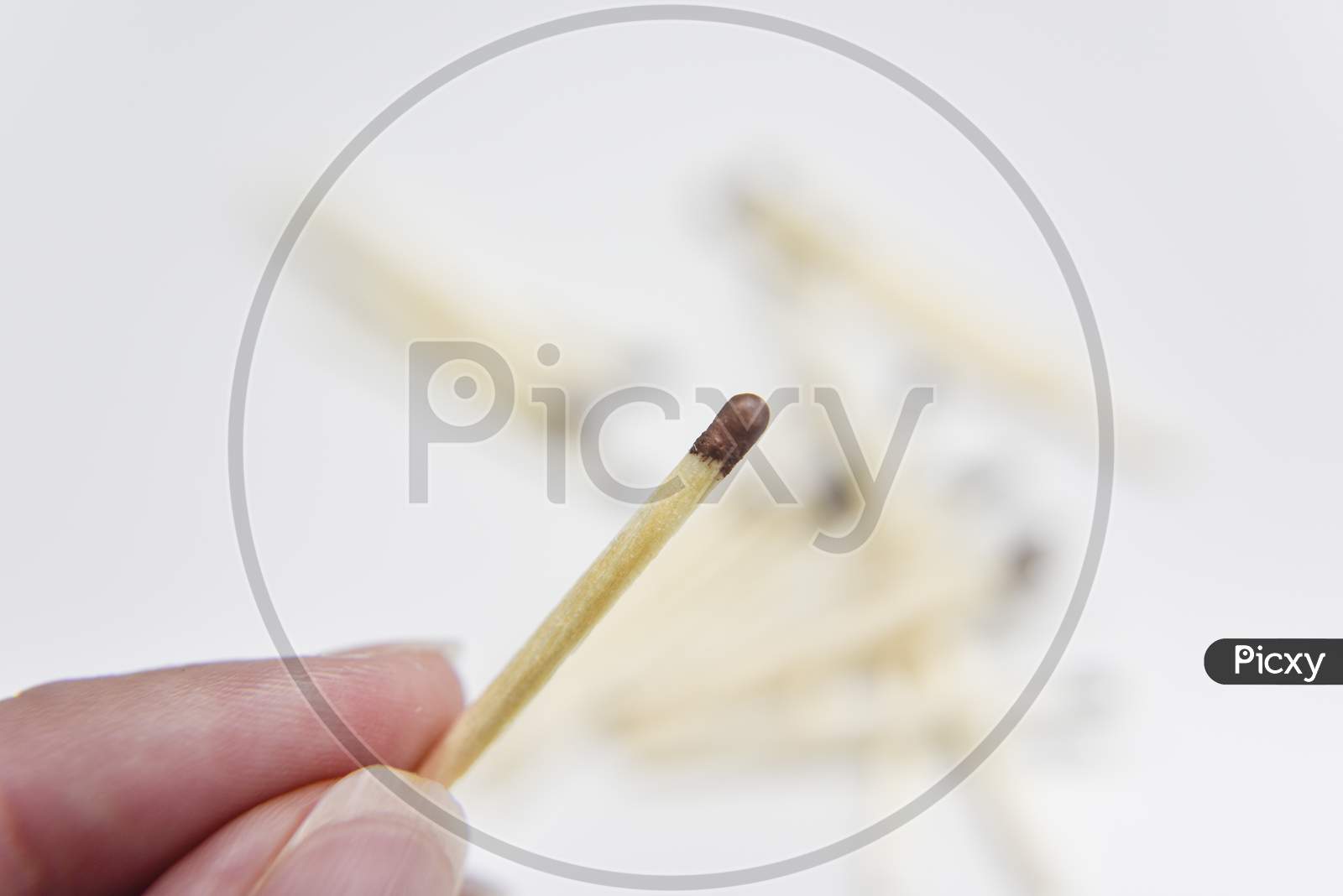 Wooden Match In The Hand With Matches On The White Backgtound. Selective Focus. Chain Reaction Concept.