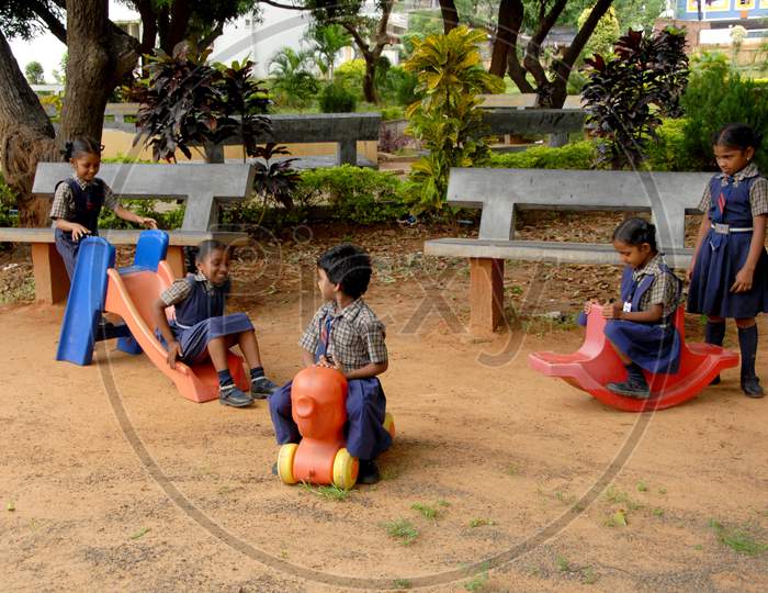School Children Playing With Amusement Park With Happy Faces
