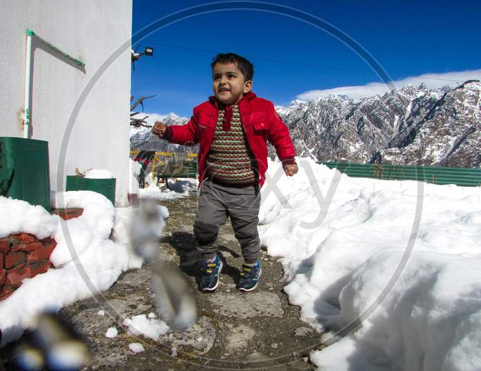 Cute child playing in snow. 