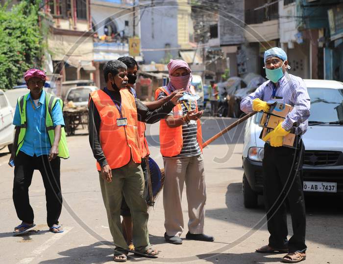 A Man Distributes Mask And Head Cover To Municipal Corporation Workers During Nationwide Lockdown In Wake Of Coronavirus  or COVID-19  Pandemic In Prayagraj, March 12, 2020.