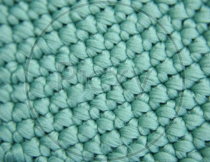 Repeating Texture Of Knitted Green Fiber. Selective Focus. Close-Up Look.