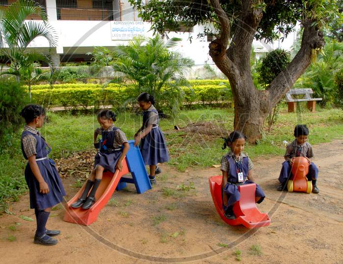School Children Playing With Amusement Park With Happy Faces