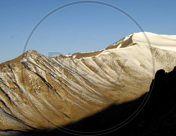 Snow Capped Mountains With Blue Sky In Background