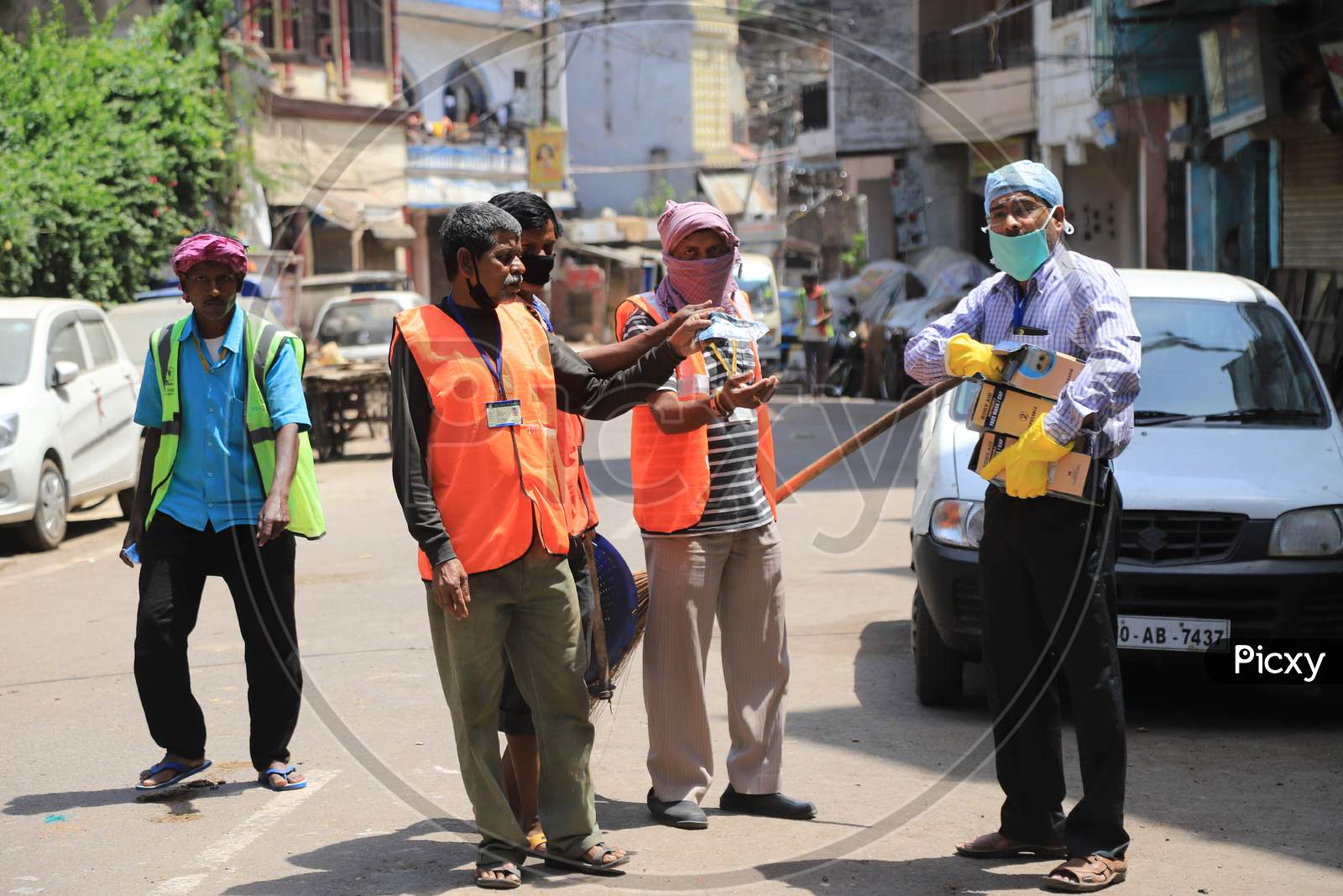 A Man Distributes Mask And Head Cover To Municipal Corporation Workers During Nationwide Lockdown In Wake Of Coronavirus  or COVID-19  Pandemic In Prayagraj, March 12, 2020.