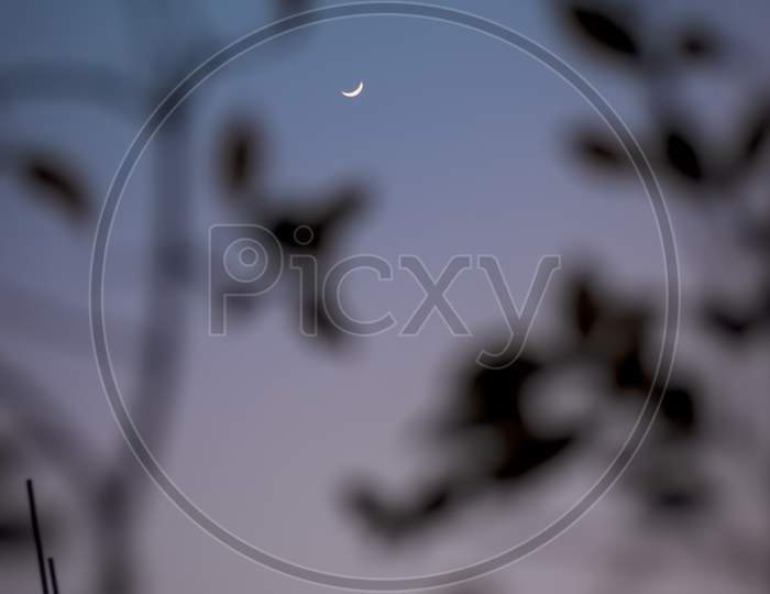 Selective focus on subject which is a new moon in blue sky