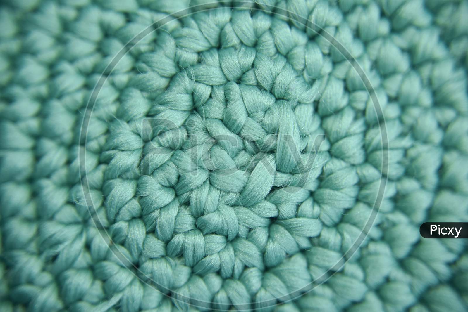 Center Focused Knitted Pattern Of Green Fiber In The Shape Of Vortex. Selective Focus.