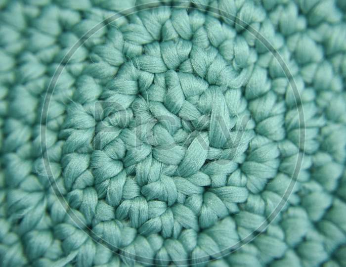 Center Focused Knitted Pattern Of Green Fiber In The Shape Of Vortex. Selective Focus.