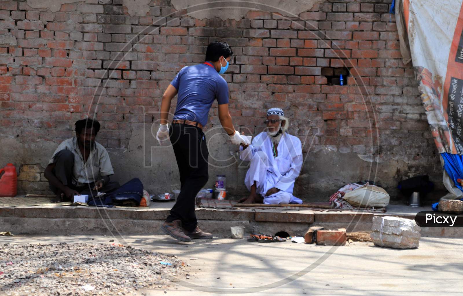 A Man Distributes Food To Homeless People During Nationwide Lockdown In Wake Of Coronavirus or COVID-19  Pandemic In Prayagraj, March 12, 2020.
