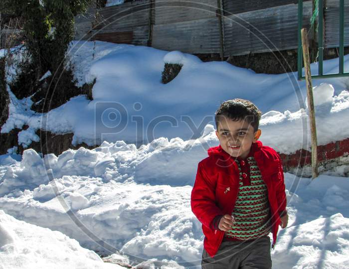 Cute child playing in snow.
