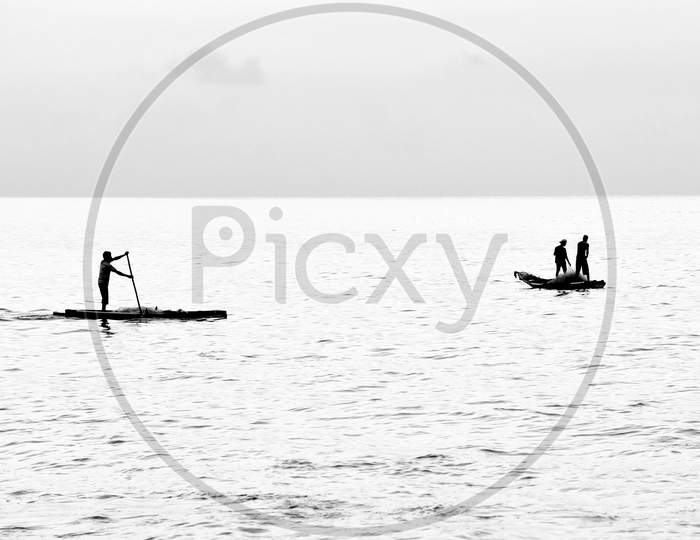 Silhouette Of Fisherman Fishing On Sea
