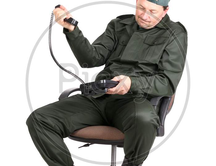 Man In Workwear Sitting With Phone. Isolated On A White Background.
