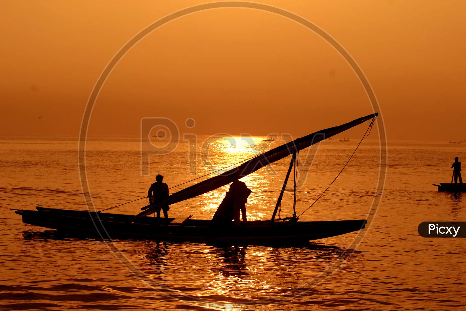 Silhouette Pf Fisherman Sailing For Fish On Sea With Sunset Sky in Background