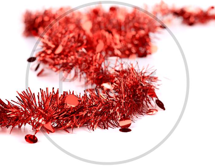 Christmas Red Tinsel With Stars. Blurred Background.