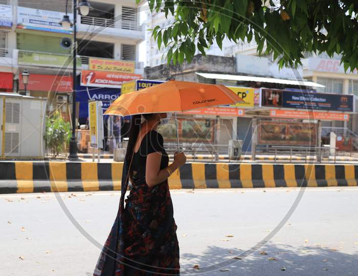 A Woman Use Umbrella Walk On The Empty Road During Nationwide Lockdown In Wake Of Coronavirus or covid-19  Pandemic In Prayagraj, March 13, 2020.