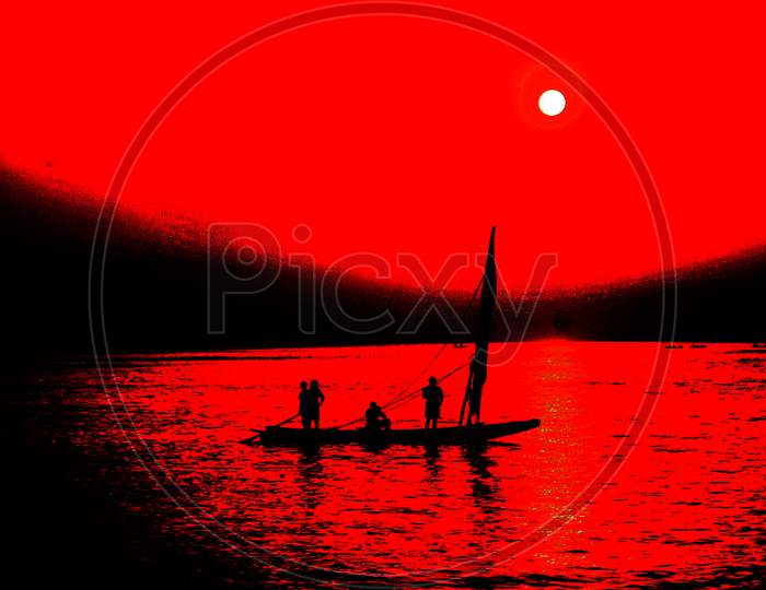Silhouette Pf Fisherman Sailing For Fish On Sea With Sunset Sky in Background