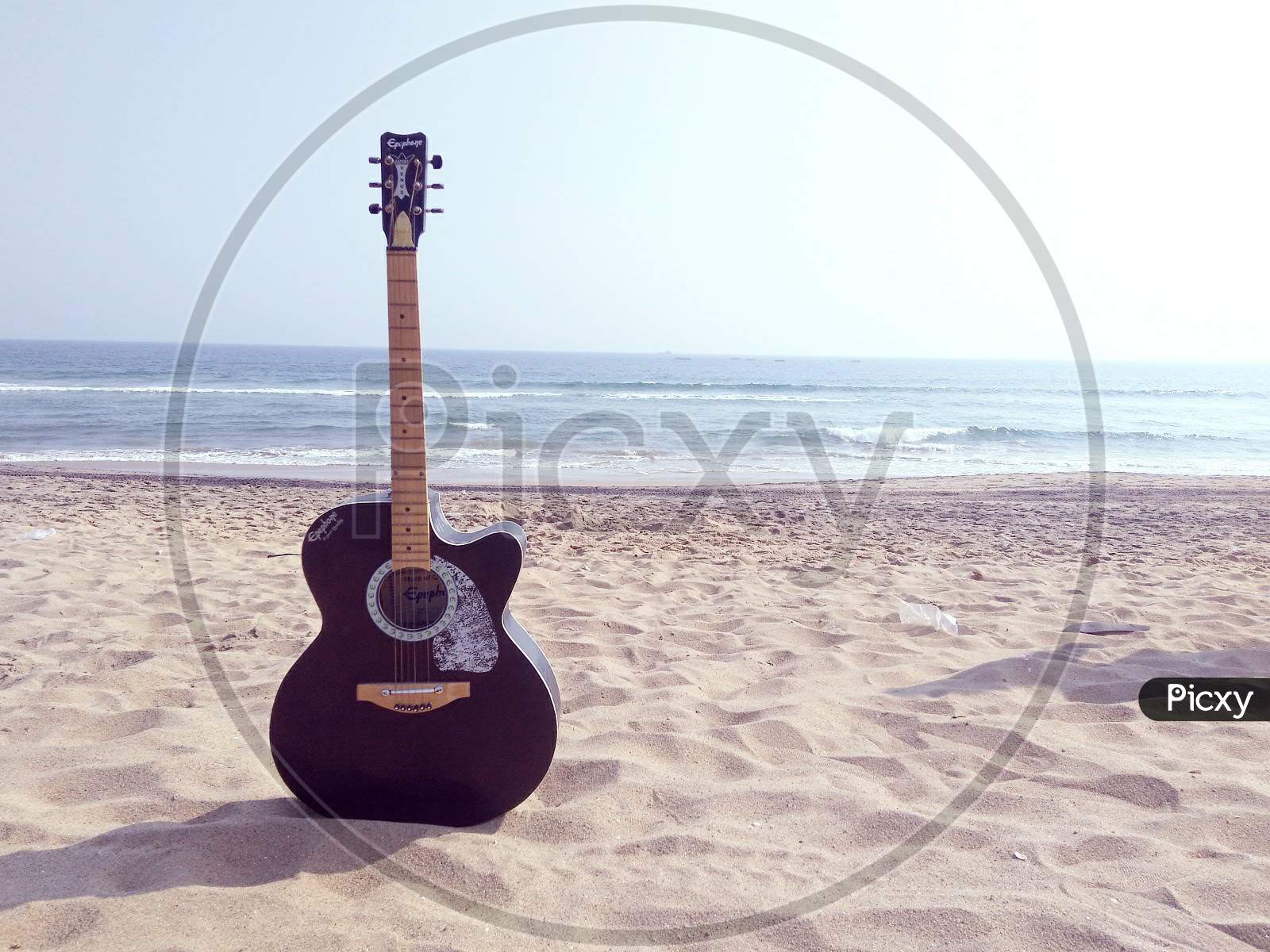 Guitar on a Beach With Sea in Background
