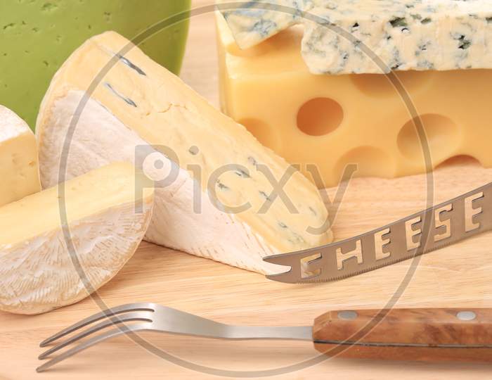 Various Types Of Cheeses On Wood. With Knife. Whole Background.