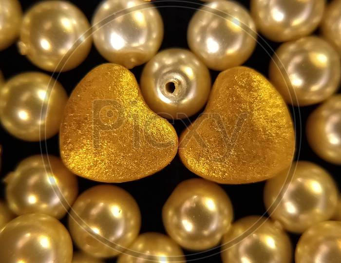 American pearls with heart shaped object. Golden hearts and pearls. Close up of pearls.